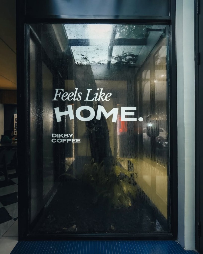 Pintu kaca Dikby Coffee dengan tulisan Feels Like Home